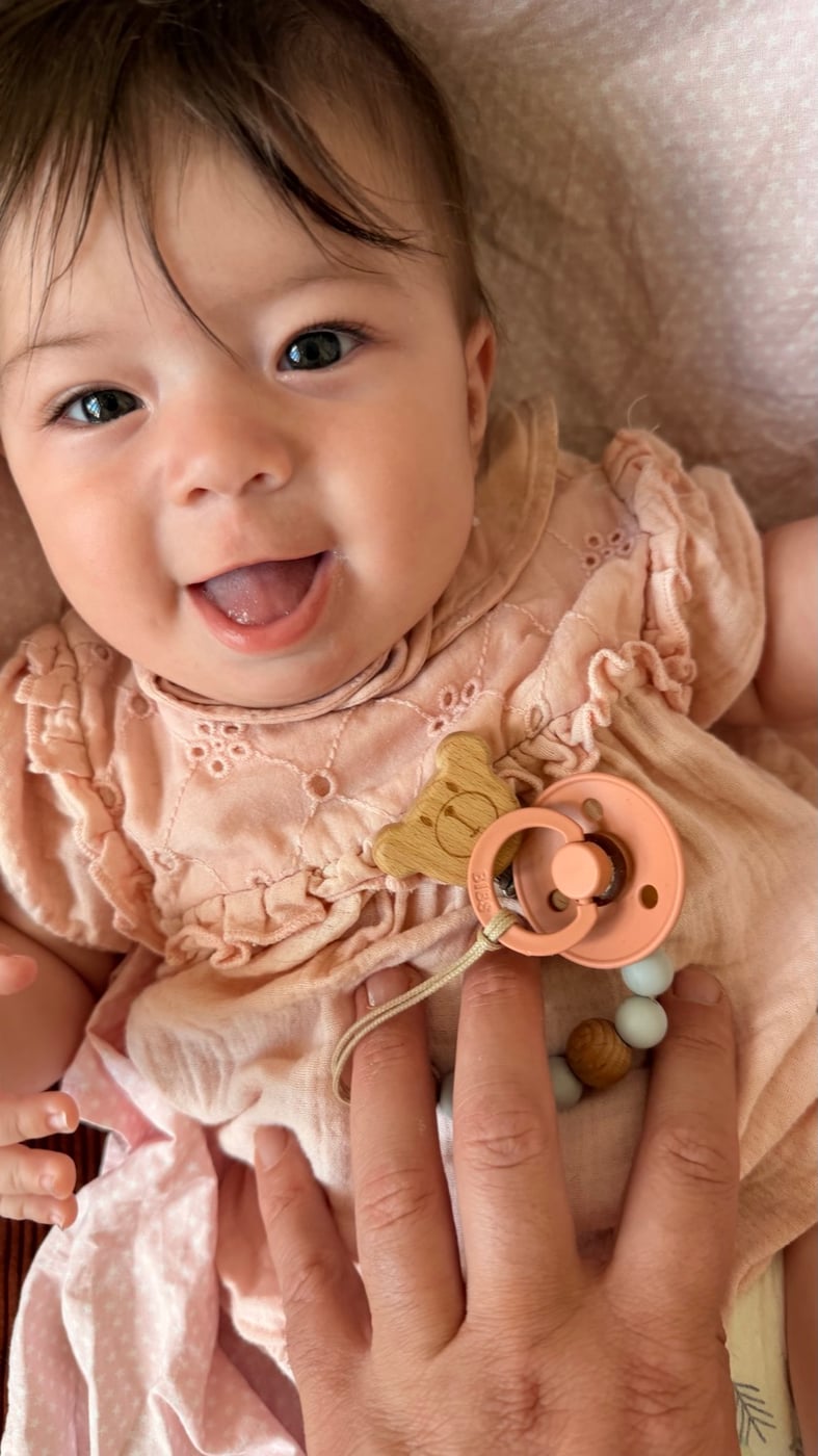 A smiling baby in a pink outfit, from the Boodoo family photo collection