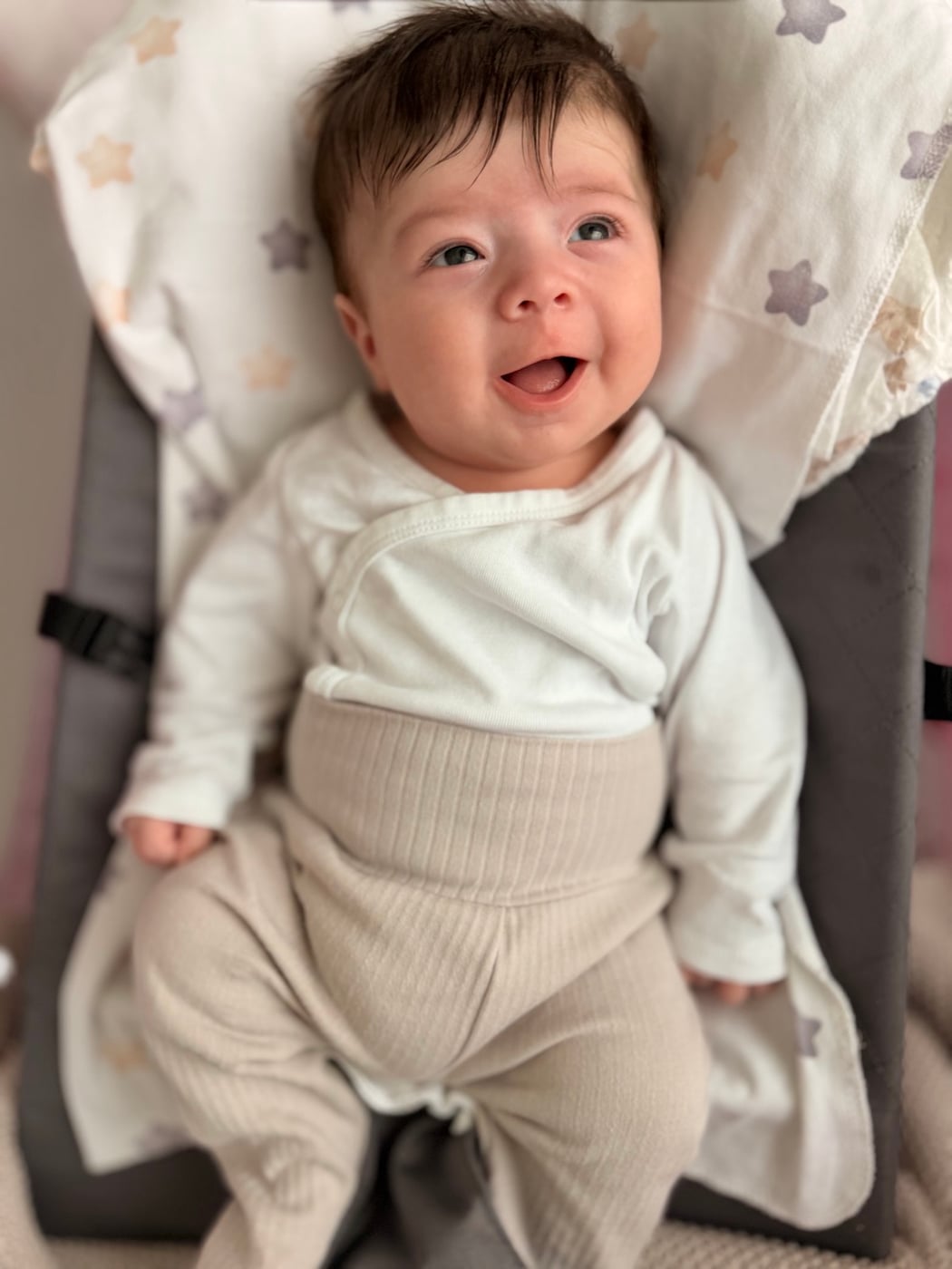 A baby smiling up at the camera